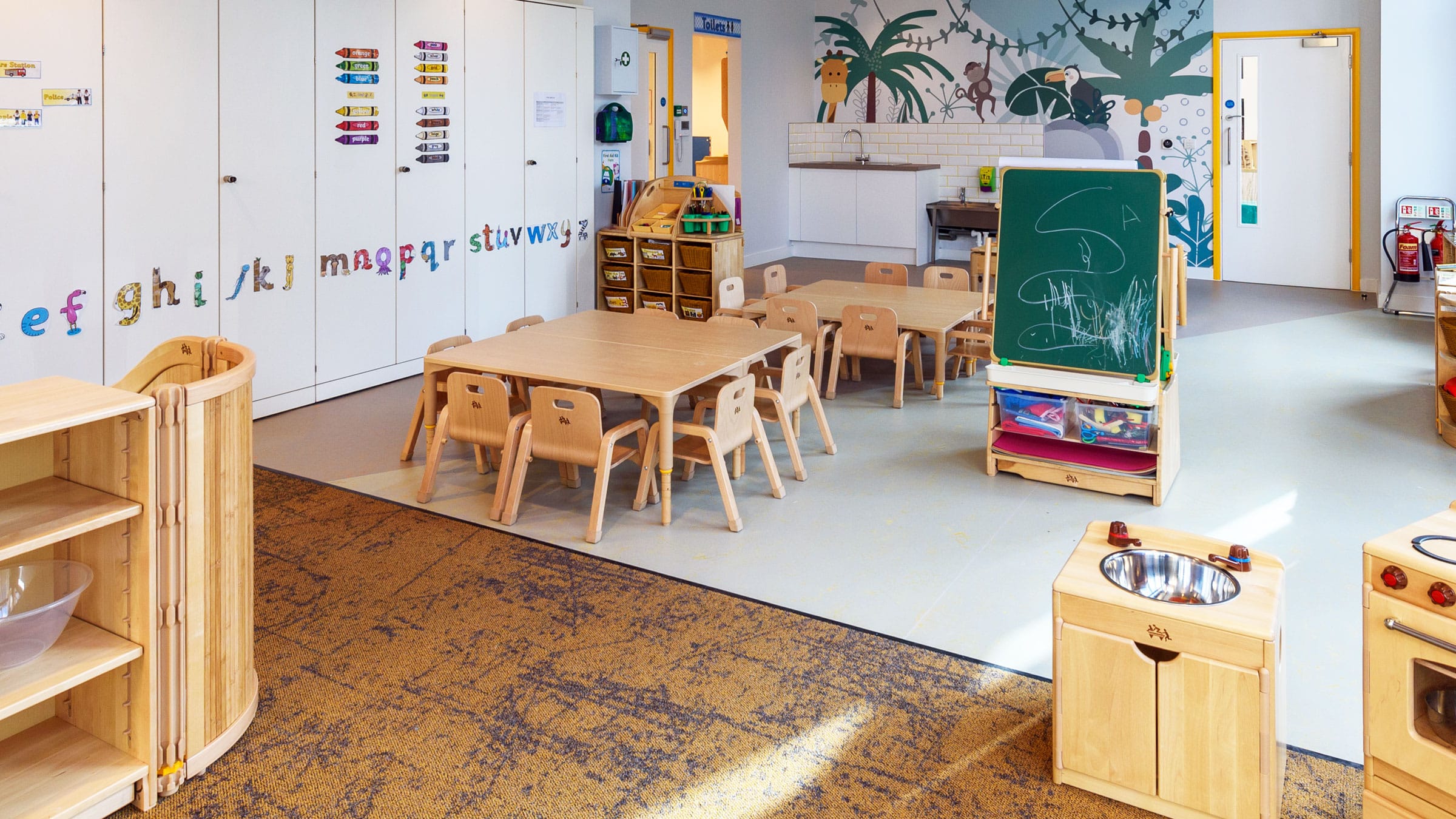 Childrens daycare interior wooden tables and chalkboard