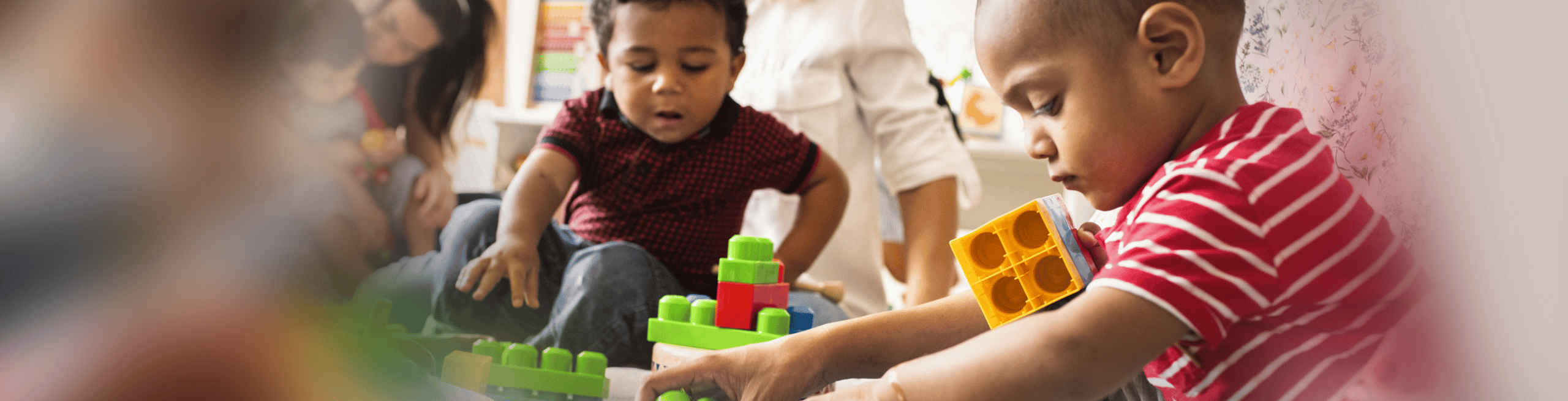 wide banner of children playing together with building blocks